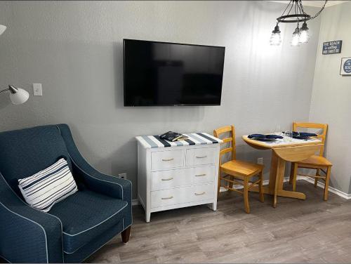 - un salon avec une télévision, une chaise et une table dans l'établissement Sea Chase with an ocean view at Casa Del Mar, à Galveston