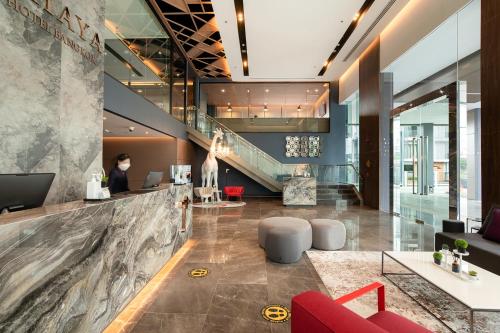 an office lobby with a staircase and red chairs at Thaya Hotel Bangkok in Bangkok