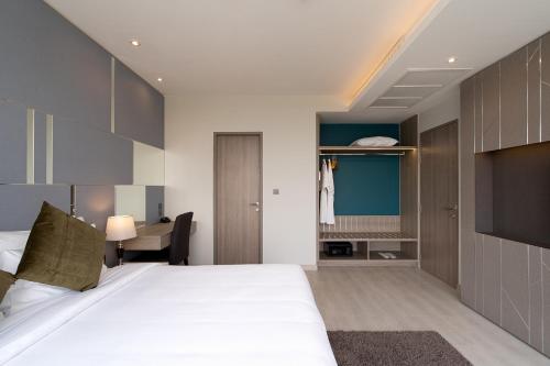a bedroom with a large bed and a desk at Thaya Hotel Bangkok in Bangkok