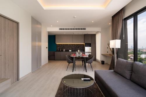 a living room with a couch and a table at Thaya Hotel Bangkok in Bangkok