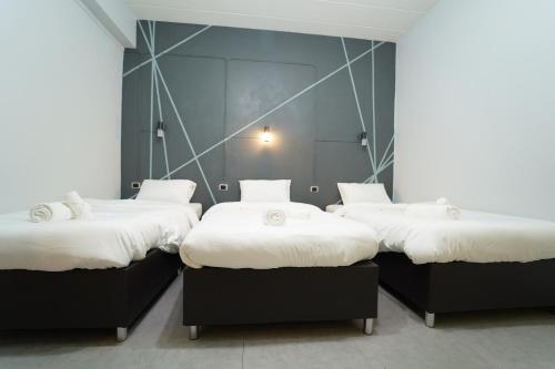 three beds in a room with white sheets at Chillax Khaosok Hostel - SHA Certified in Khao Sok