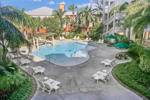 a swimming pool with chairs and umbrellas next to a building at Sea Chase with an ocean view at Casa Del Mar in Galveston