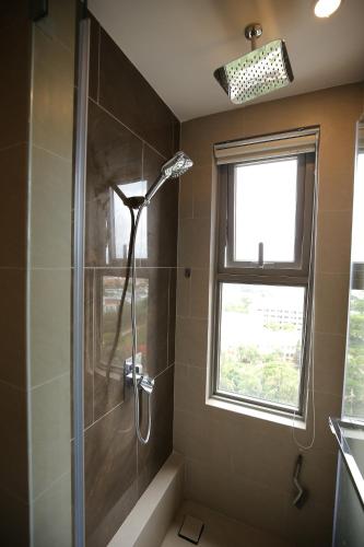 een douche in een badkamer met een raam bij Son Thuy's House -Luxury Apartment The Sóng Vũng Tàu in Vung Tau