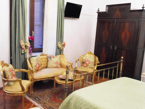 a bedroom with two chairs and a bed at Art&Coffee in Verona