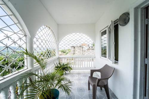 Habitación con 2 sillas, mesa y ventanas en Skyline Suites 2 Queen bedroom condo en Montego Bay