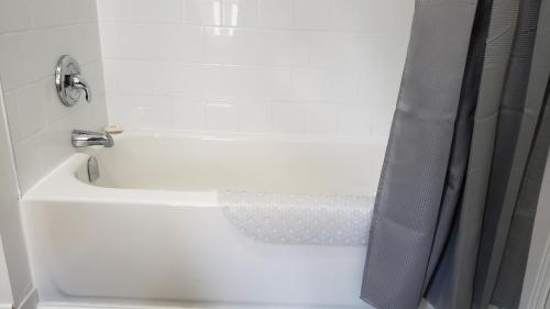 a white bath tub with a shower curtain in a bathroom at L'escale du routard in Alma