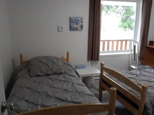 a bedroom with a bed and a window at L'escale du routard in Alma