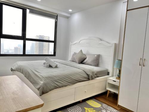 a white bedroom with a large bed and two windows at ECOPARK APATMENT CĂN HỘ 1 PHÒNG NGỦ in Kim Quan
