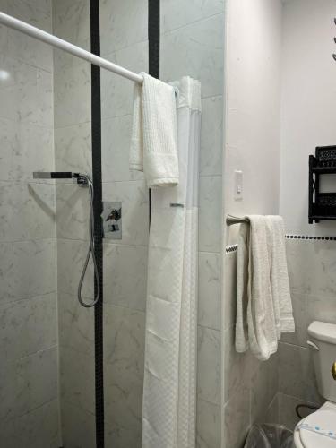 La salle de bains est pourvue d'une douche et de serviettes blanches. dans l'établissement Americas Best Value Inn Royal Carriage, à Jamestown