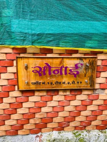 a sign on the side of a brick wall at sonai POWERED BY PEACEFUL STUDIO in Panvel