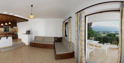 a living room with a balcony with a couch and a table at Marialice in Dassia