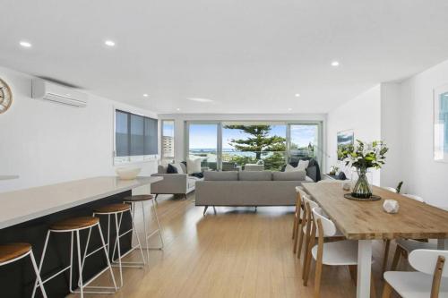 a kitchen and living room with a table and chairs at Beachside Living with Sea Views at the Pines in Ocean Grove