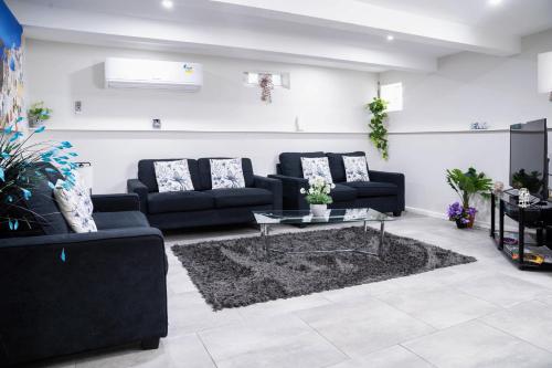 a living room with two black couches and a table at Sherrard Spacious Family Place in Nerrina