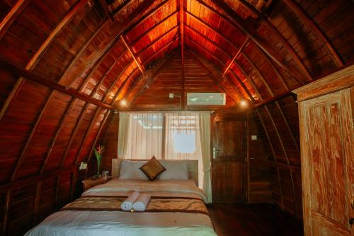 1 dormitorio con 1 cama en una habitación de madera en Ita House, en Tegalalang