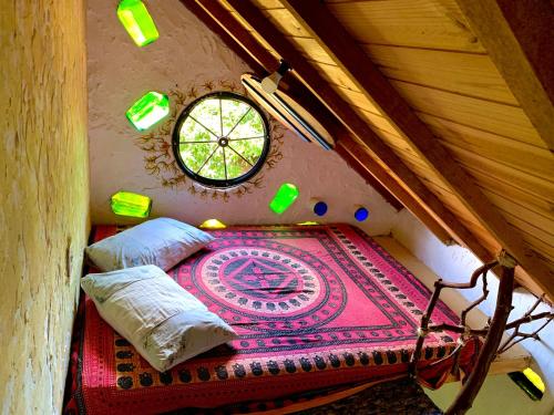 an attic room with a bed and a window at Camping Nomadas in Bonito