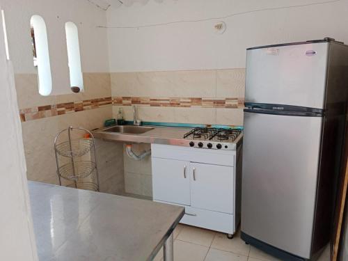 a kitchen with a white refrigerator and a sink at Villa Ines R in Chinauta