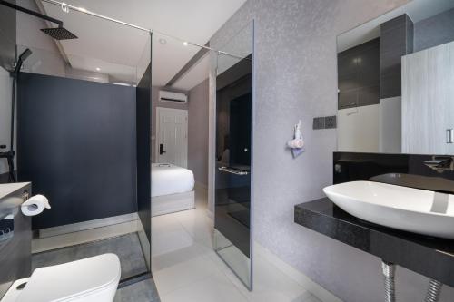 a bathroom with a sink and a toilet at Mari Hotel By Connek in Ho Chi Minh City