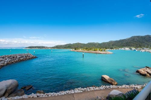 a view of a large body of water with rocks at One Bright Point - Stunning Water Views in Nelly Bay