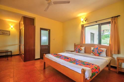 Schlafzimmer mit einem großen Bett und einem Fenster in der Unterkunft Amazing Hilltop 3BHK Villa with Swimming Pool in Velha Goa