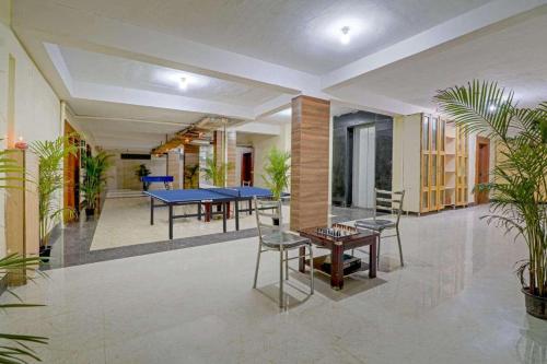 a room with ping pong tables and potted plants at Hotel Terminal View in Bangalore