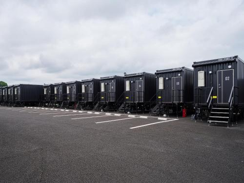 a row of black containers parked in a parking lot at HOTEL R9 The Yard Koka in Koka