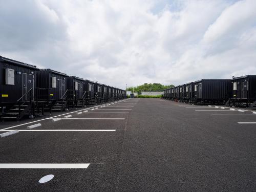 a long line of train cars parked on a road at HOTEL R9 The Yard Koka in Koka