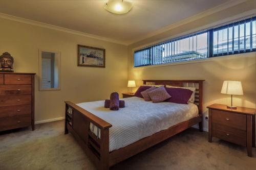 um quarto com uma cama grande e uma janela grande em Torquay Homestay Guesthouse em Torquay