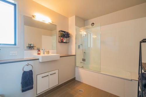 La salle de bains est pourvue d'une douche et d'un lavabo. dans l'établissement Waterways Serenity, à Whitianga