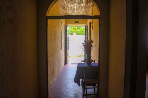 un pasillo abierto con una mesa y una puerta a una habitación en Casarão dos Uchoa en Guaramiranga