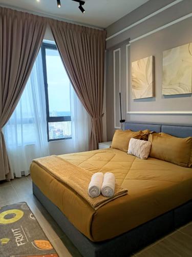 a bedroom with a large bed with two towels on it at BR Troika Homestay in Kota Bharu