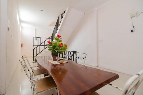 a dining room with a wooden table and chairs at RedDoorz At Fella Homestay Medan in Medan