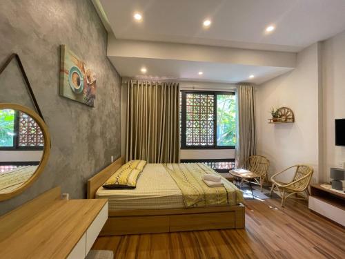 un dormitorio con una cama y un espejo en Mango Home & Apartment, en Da Nang