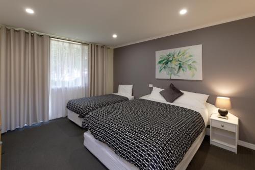 sypialnia z 2 łóżkami i oknem w obiekcie Keilor Motor Inn w mieście Keilor