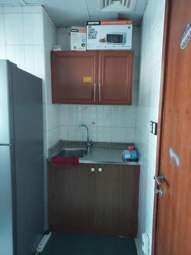 uma pequena cozinha com um lavatório e um micro-ondas em GRACE BEDSPACE, HOSTEL AND ACCOMODATIONS no Dubai