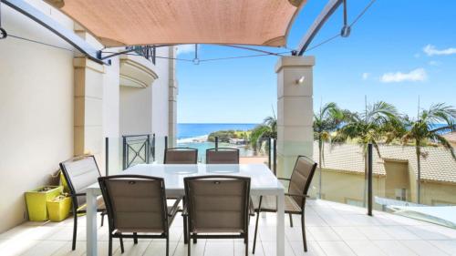 una mesa y sillas en un balcón con vistas al océano en Unit 13 - 3 Bedroom Ocean View, en Terrigal
