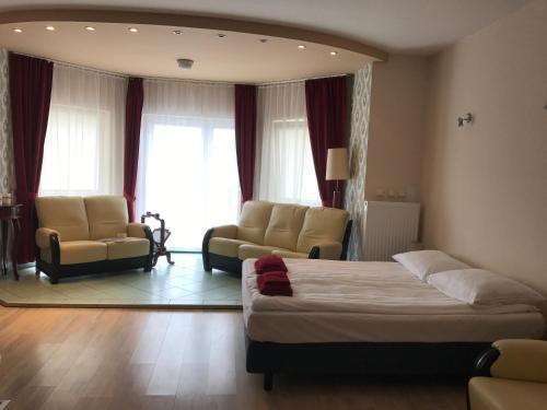a bedroom with a bed and two chairs and a couch at Centrum Noclegowe Apartament 5 in Bydgoszcz