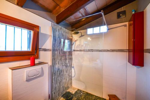 uma casa de banho com um chuveiro e uma porta de vidro em Villa Mosteiro, 'The Cosy Corner' em Santa Margalida