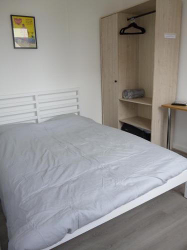 a bedroom with a white bed and a closet at Cambuse Appartement à Sangatte au premier étage à 50 metres de la plage in Sangatte