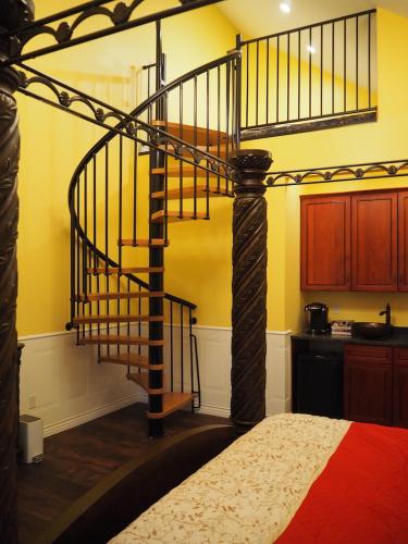 a spiral staircase in a room with a bed at Bear Creek Falls Lodge on 67 acres Creek & Waterfalls in Millville