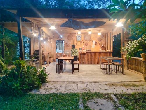 un patio con mesas y sillas por la noche en Kohmook Nurse House, en Ko Mook