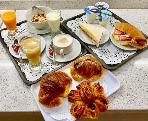 a table with two trays of breakfast foods and drinks at Optimus B&B in Rome