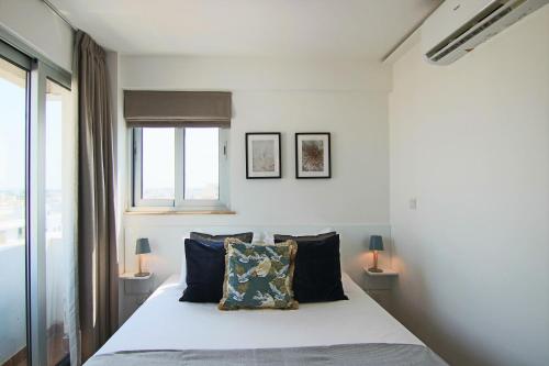 a bedroom with a bed and two lamps and a window at Phaedrus Living: Luxury Suite Nicosia 510 in Nicosia