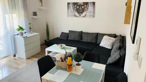 uma sala de estar com um sofá preto e uma mesa em Central Home Apartment in the City center em Eger