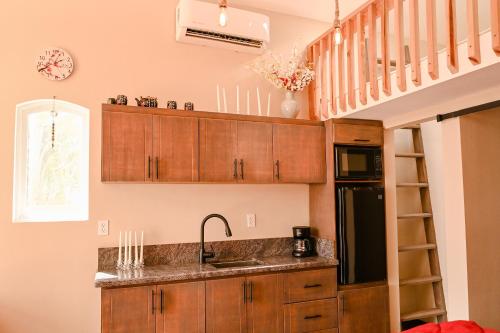 una cocina con armarios de madera, un lavabo y una escalera en Ariels Paraiso- Ocean view, en Primo Tapia