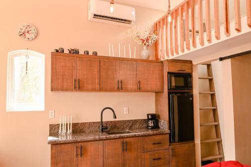 a kitchen with wooden cabinets and a sink and a staircase at Ariels Paraiso- Ocean view in Primo Tapia