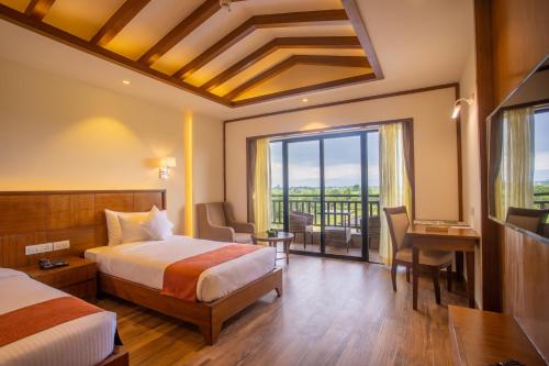 a hotel room with a bed and a large window at Soaltee Westend Resort Chitwan in Chitwan
