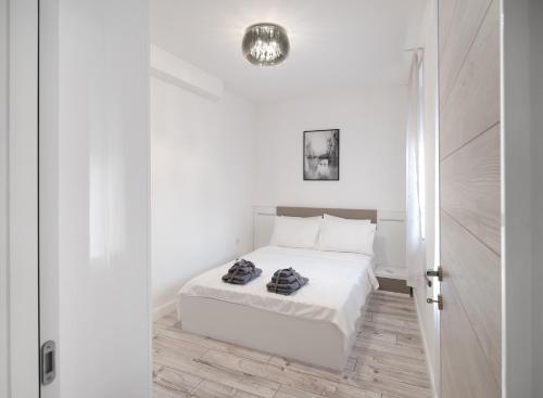um quarto branco com uma cama com lençóis brancos em Beautiful Place in The Heart of The City!!!! em Plovdiv