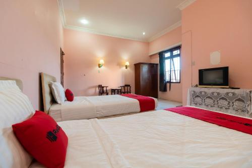 a hotel room with two beds and a television at RedDoorz near Silangit International Airport in Siborongborong