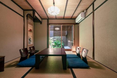 京都Rinn Nishiwakamatsu的一间有桌子、椅子和窗户的餐厅