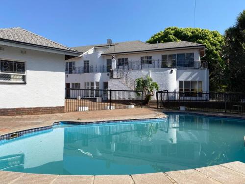 a large swimming pool in front of a building at Chic Guest House & Solar system free from load shedding in Germiston